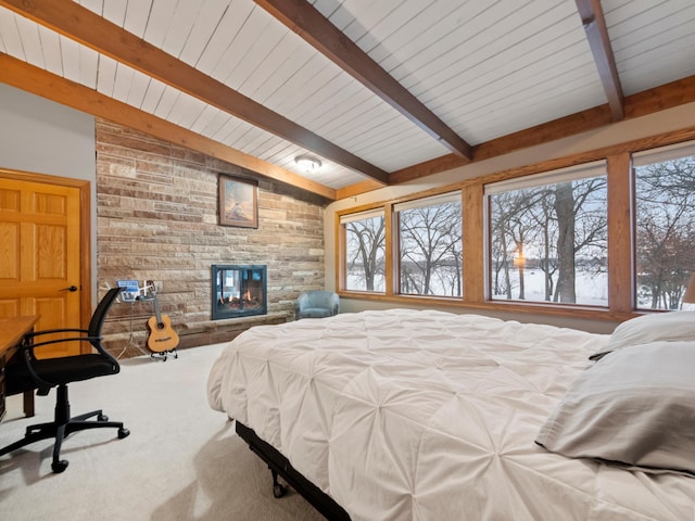 carpeted bedroom featuring a fireplace and vaulted ceiling with beams