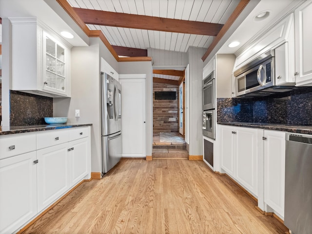 kitchen featuring beamed ceiling, tasteful backsplash, white cabinets, light hardwood / wood-style floors, and stainless steel appliances