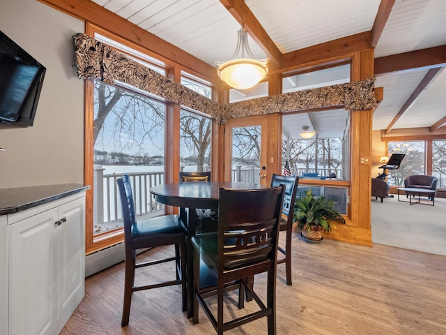 dining room with light wood-type flooring and beam ceiling