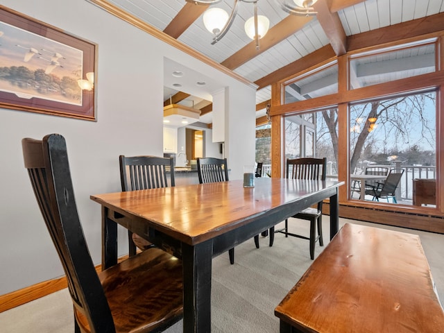 dining room with lofted ceiling with beams and light colored carpet