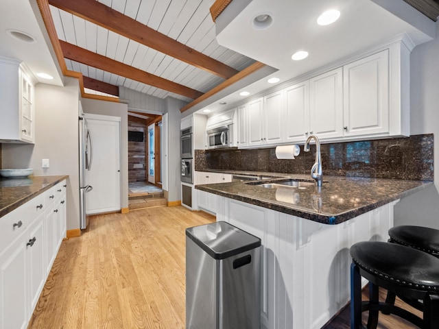 kitchen featuring tasteful backsplash, sink, white cabinets, wood ceiling, and stainless steel appliances