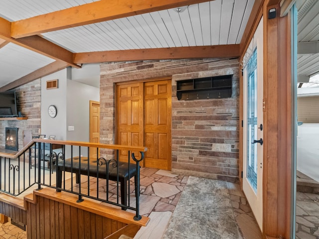 foyer featuring vaulted ceiling with beams