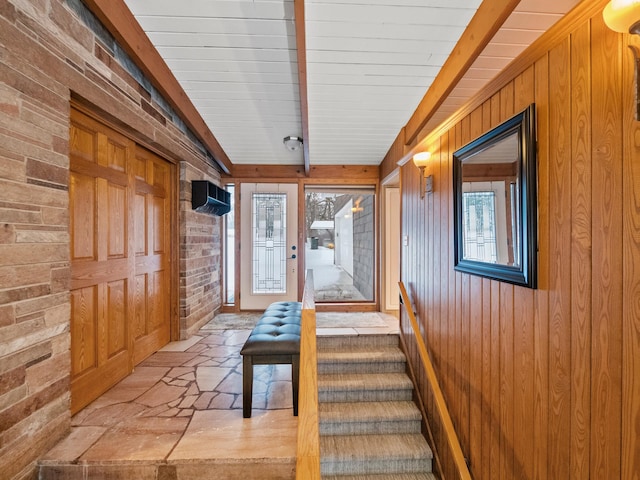 interior space featuring lofted ceiling and wooden walls