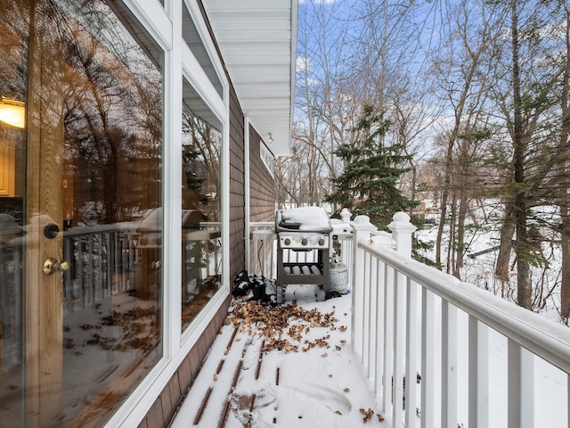 snow covered back of property with a grill