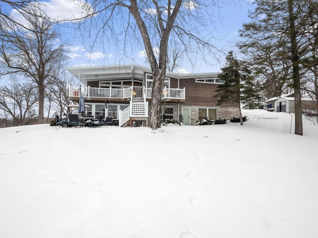 snow covered house featuring covered porch