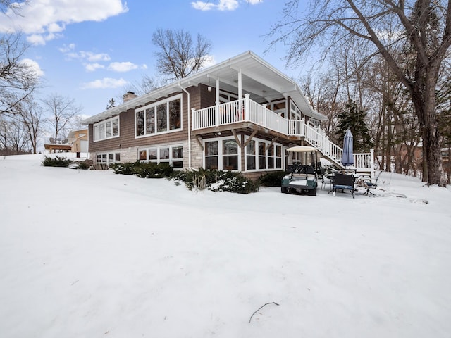 snow covered property with a chimney