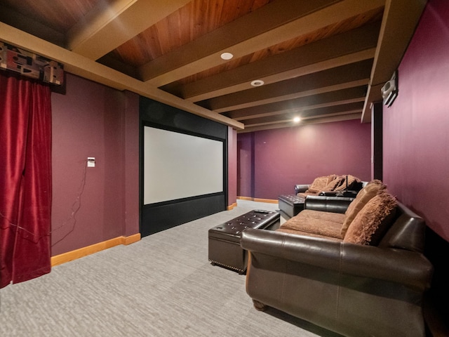 carpeted cinema room featuring beamed ceiling and baseboards