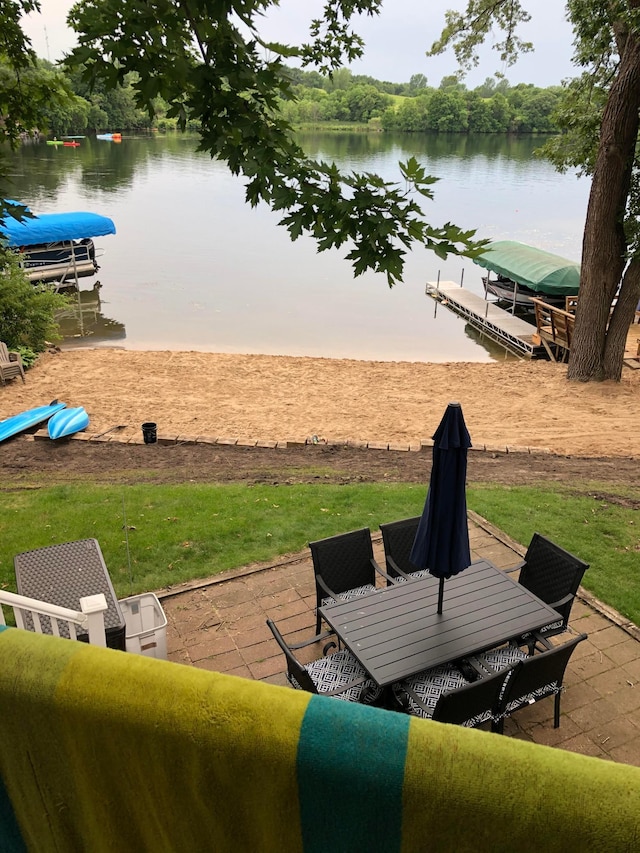 view of patio / terrace with a water view and a boat dock