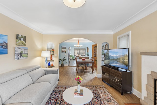 living room with a chandelier, wood-type flooring, and ornamental molding