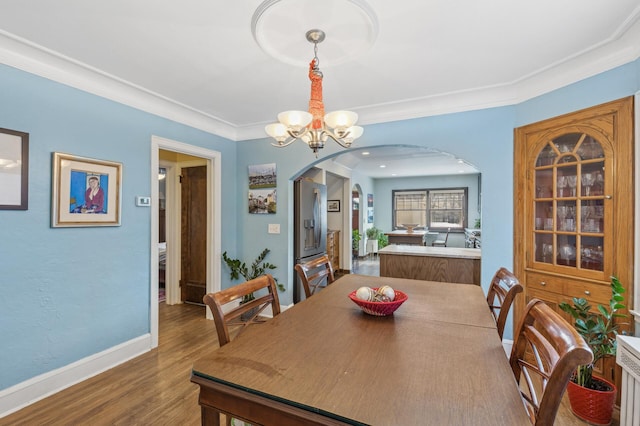 dining space with a chandelier, crown molding, and hardwood / wood-style flooring