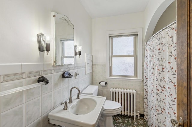 bathroom with a healthy amount of sunlight, sink, tile walls, and radiator heating unit