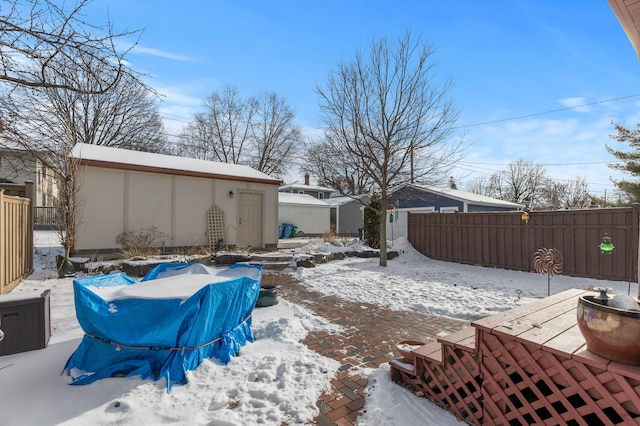 snow covered patio with a shed