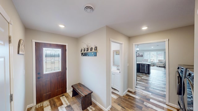 entrance foyer featuring hardwood / wood-style flooring, sink, and independent washer and dryer