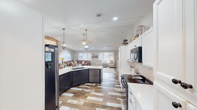 kitchen with ceiling fan, stainless steel appliances, light hardwood / wood-style floors, decorative backsplash, and white cabinets