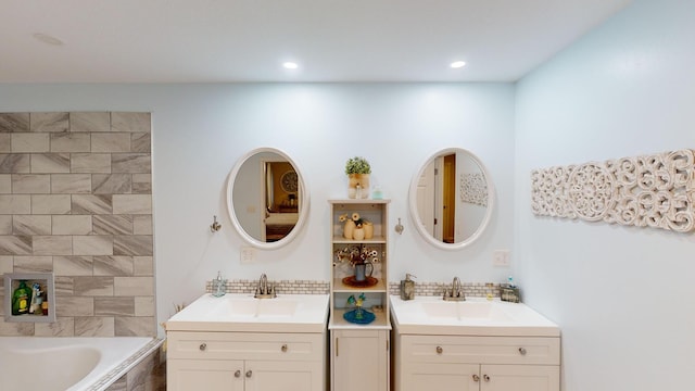 bathroom featuring tiled bath and vanity