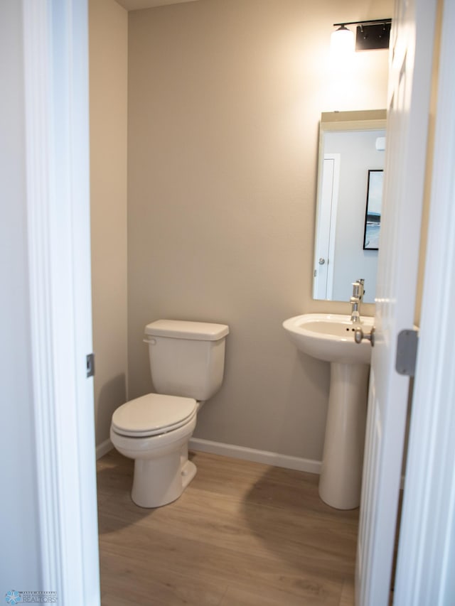 bathroom with toilet and hardwood / wood-style floors