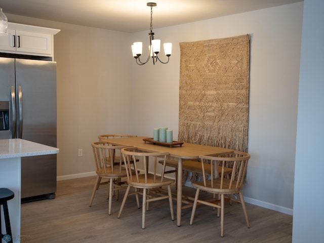 dining area with hardwood / wood-style flooring and a chandelier