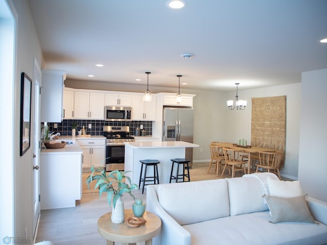 living room featuring light hardwood / wood-style flooring, sink, and an inviting chandelier