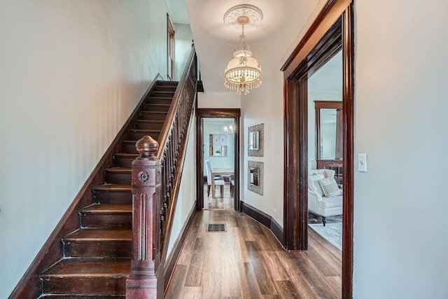 723 Lowry Ave NE, Minneapolis, MN 55418 - stairway featuring a chandelier, wood finished floors, and baseboards