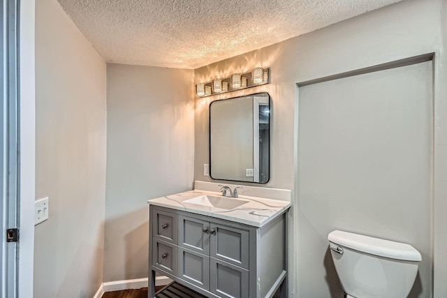 723 Lowry Ave NE, Minneapolis, MN 55418 - bathroom with a textured ceiling, vanity, toilet, and wood finished floors
