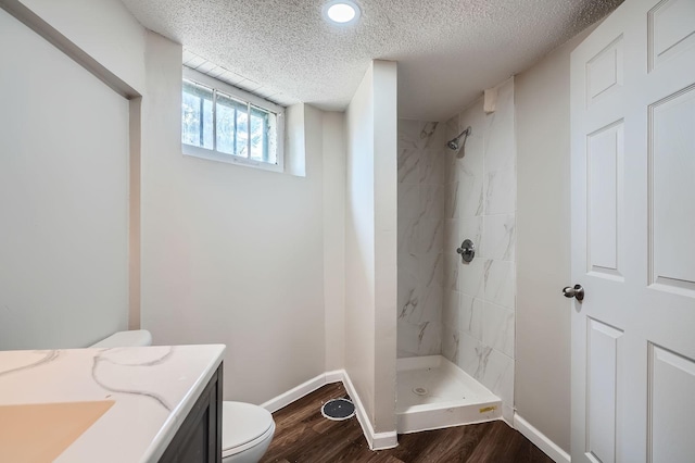 723 Lowry Ave NE, Minneapolis, MN 55418 - full bath with toilet, a tile shower, baseboards, wood finished floors, and a textured ceiling