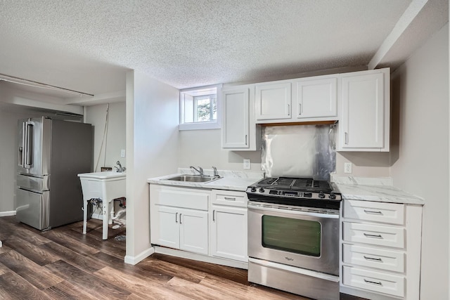 723 Lowry Ave NE, Minneapolis, MN 55418 - kitchen featuring stainless steel appliances, a textured ceiling, dark wood finished floors, white cabinetry, and a sink