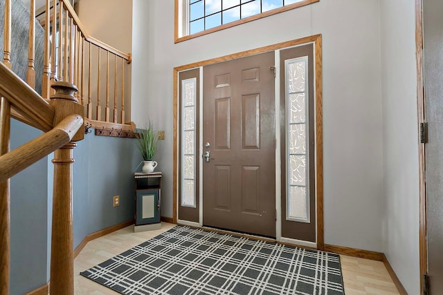 foyer featuring wood-type flooring and a high ceiling