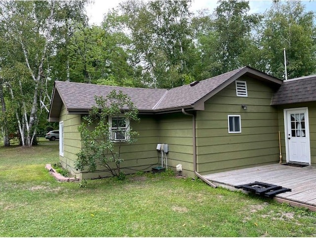 rear view of house with a deck and a yard