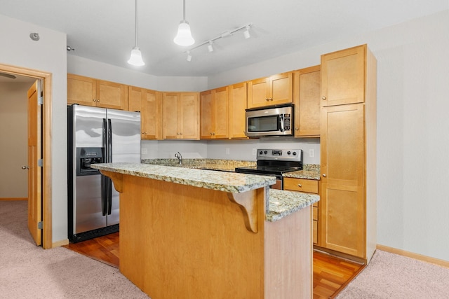 kitchen featuring pendant lighting, stainless steel appliances, a breakfast bar, and an island with sink