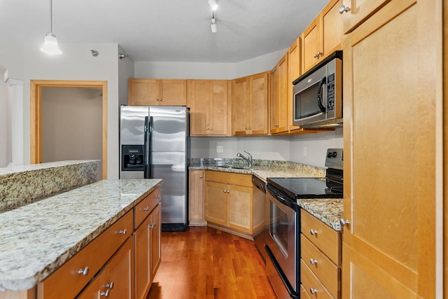 kitchen featuring sink, hanging light fixtures, track lighting, dark hardwood / wood-style flooring, and stainless steel appliances