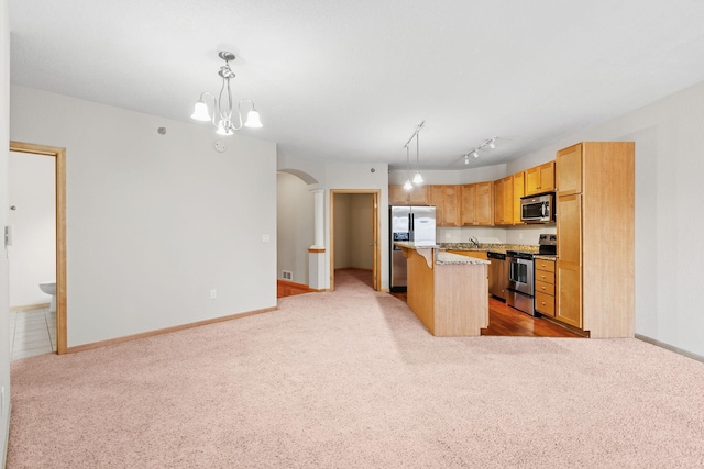 kitchen featuring a kitchen island, a kitchen breakfast bar, hanging light fixtures, light colored carpet, and stainless steel appliances