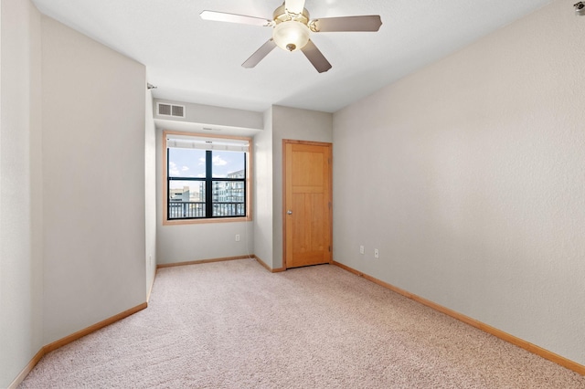 carpeted spare room with ceiling fan