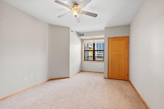 carpeted spare room featuring ceiling fan