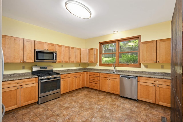 451 Everett St N, Stillwater, MN 55082 - kitchen featuring stainless steel appliances, a sink, dark countertops, and stone finish floors