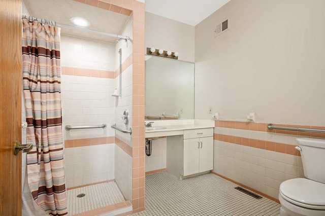 451 Everett St N, Stillwater, MN 55082 - bathroom with toilet, a stall shower, tile walls, a wainscoted wall, and vanity