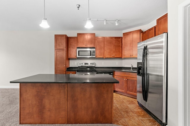 kitchen with pendant lighting, stainless steel appliances, a center island, and sink