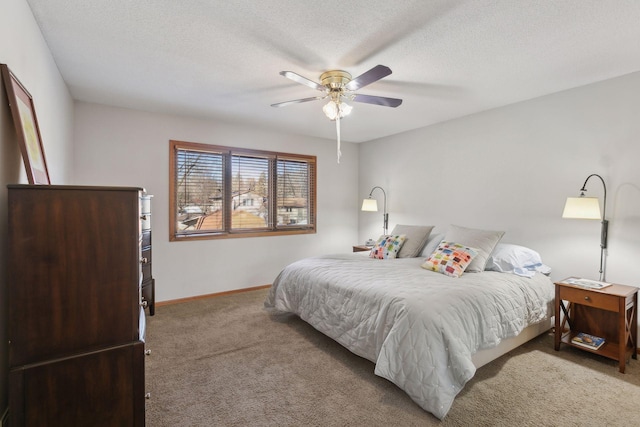 carpeted bedroom featuring ceiling fan and a textured ceiling