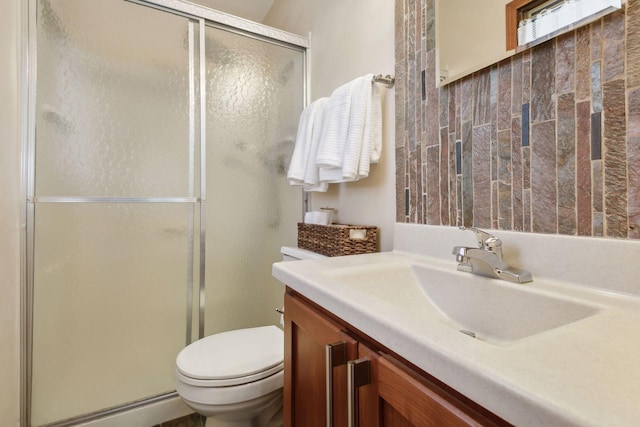 bathroom featuring an enclosed shower, vanity, and toilet