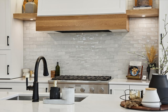 kitchen featuring decorative backsplash, white cabinets, and ventilation hood