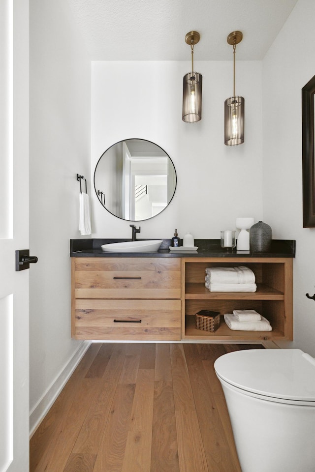 bathroom with hardwood / wood-style floors, vanity, and toilet