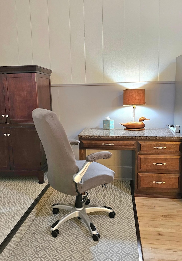 office with built in desk and light wood-type flooring