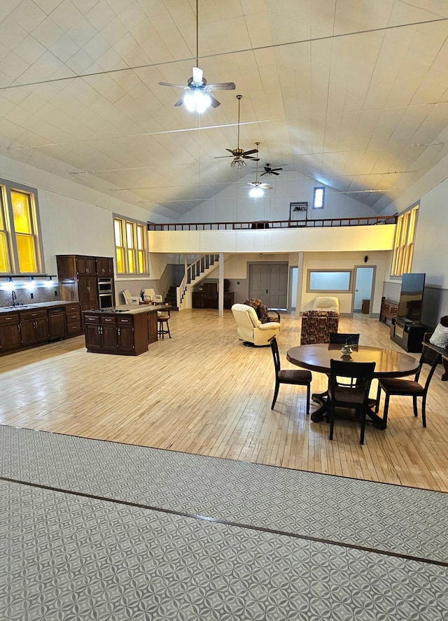 dining area featuring lofted ceiling, light hardwood / wood-style floors, and sink