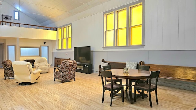 dining room with a high ceiling and light hardwood / wood-style flooring