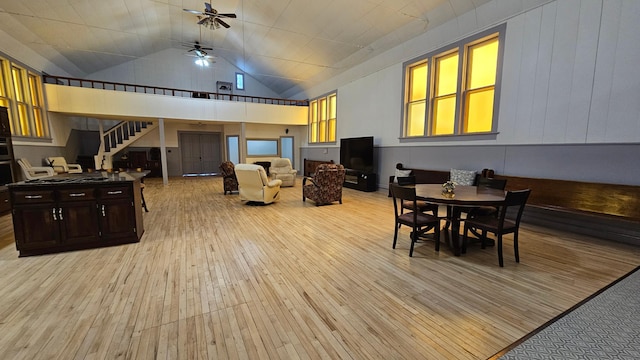 dining area featuring ceiling fan, high vaulted ceiling, and light hardwood / wood-style floors