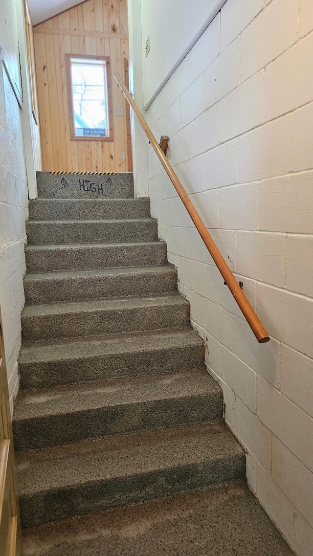 staircase featuring wood walls