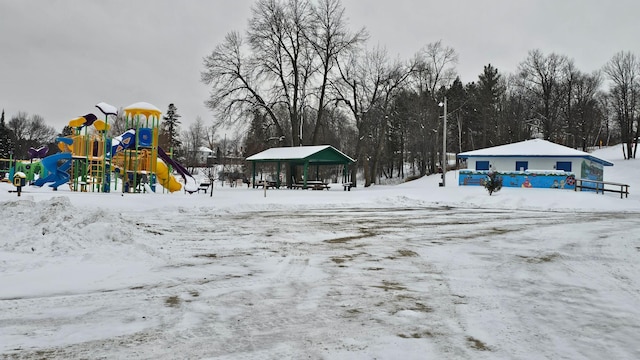 yard layered in snow featuring a playground