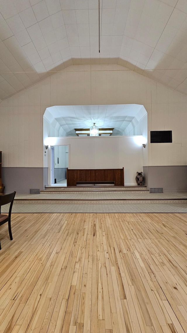 interior space featuring wood-type flooring and vaulted ceiling