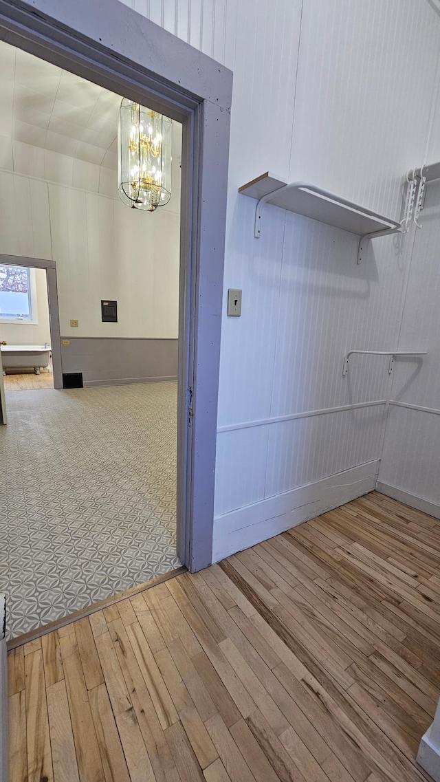 hall featuring a notable chandelier and hardwood / wood-style floors