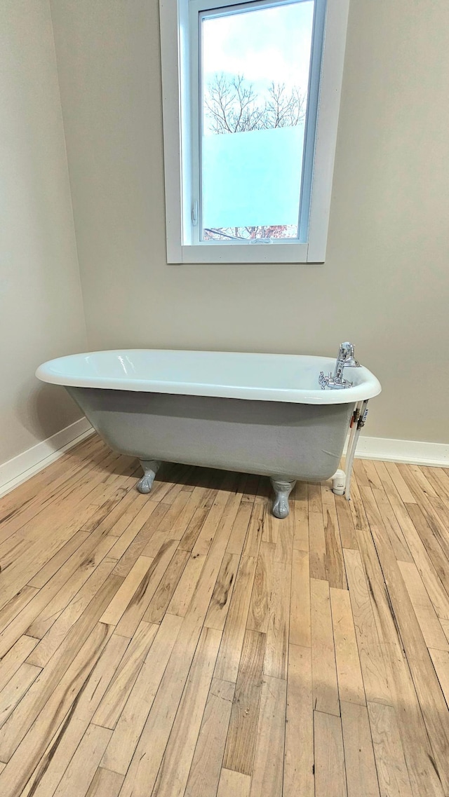 bathroom featuring wood-type flooring and a washtub