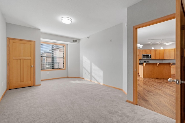 carpeted spare room with rail lighting